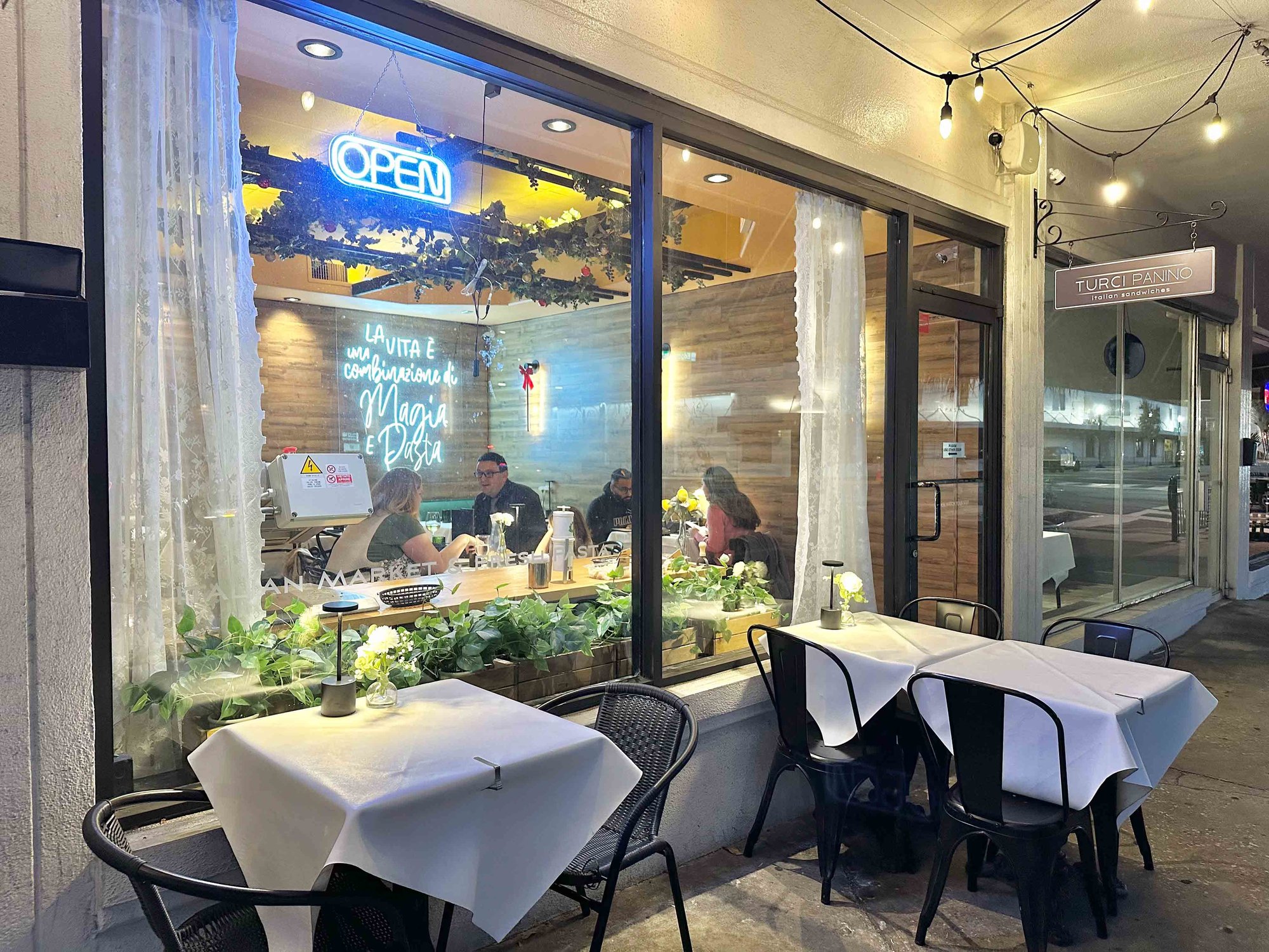 tables outside next to the glass windows leading inside the restaurant